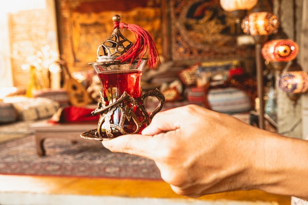 Photo hand holding or serving traditional turkish coffee tea