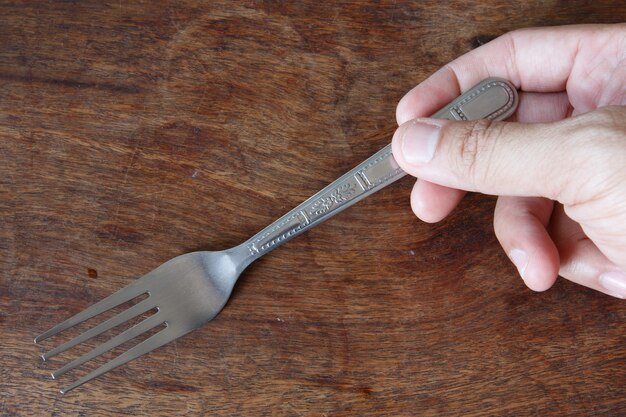 Hand holding a silver fork