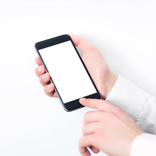 Hand holding smart mobile phone on white and light blurred background