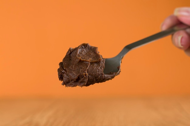 Hand holding a spoon of Brazillian chocolate sweet called Brigadeiro Vegan version