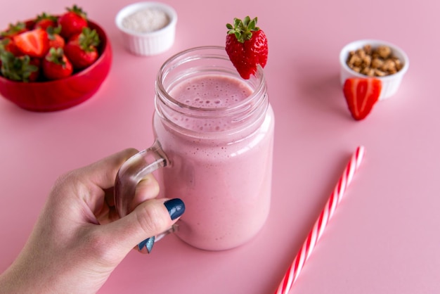 Hand holding a strawberry smoothie cup healthy shake of strawberry with milk