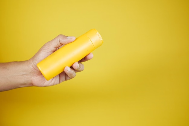 Hand holding a sunscreen cream container