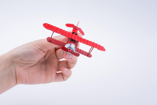 Hand holding a toy plane on a white background