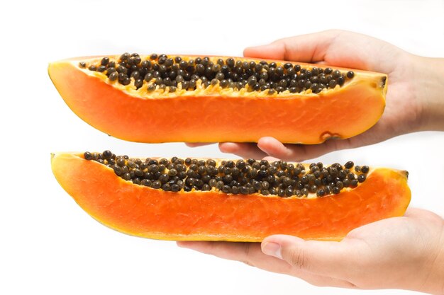 Hand holding two sliced fresh organic papaya delicious fruit isolated on white background