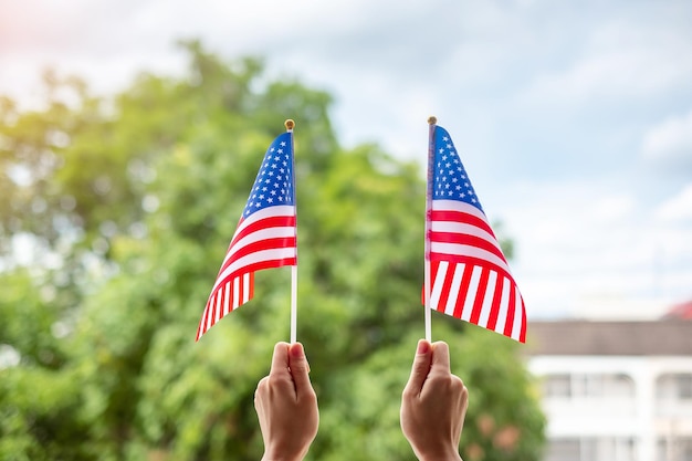 Hand holding United States of America flag on green background USA holiday of Veterans Memorial Independence Fourth of July and Labor Day concept