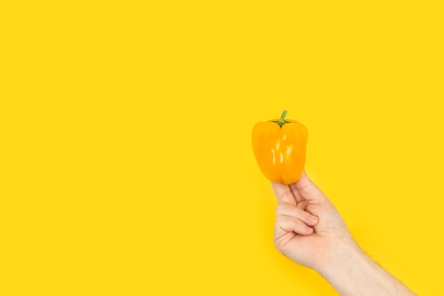 Hand holding a yellow pepper