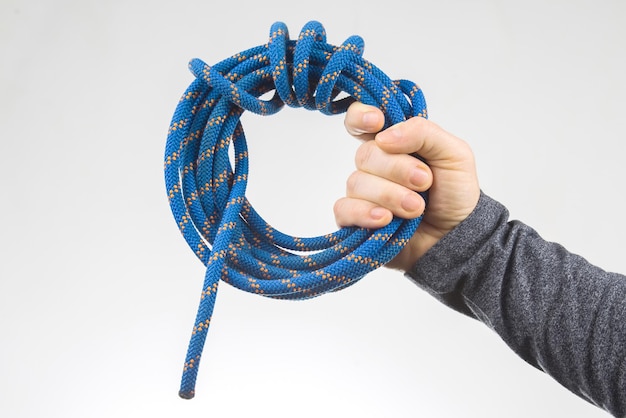 Hand holds colored rope for climbing equipment item for camping and climbing