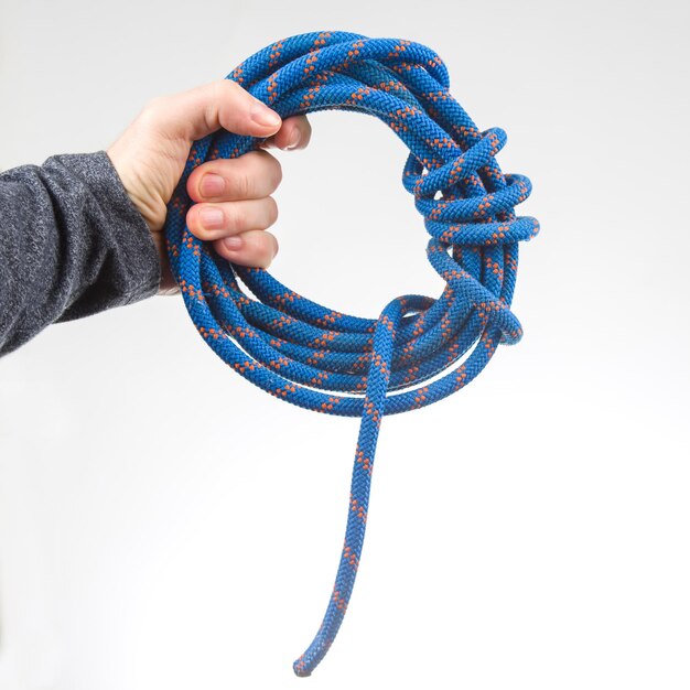 Photo hand holds colored rope for climbing equipment item for camping and climbing