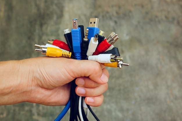 Hand holds colorful universal recharger heads.