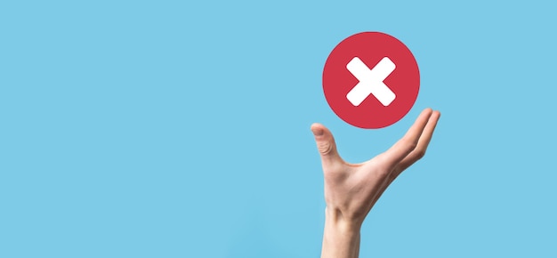 Hand holds icon,cancellation symbol,cancel icon.Cross mark flat red icon.round X mark.cancel button.Wrong.cross mark rejection.Declined.On dark background.Banner.Copy space.Place for text.