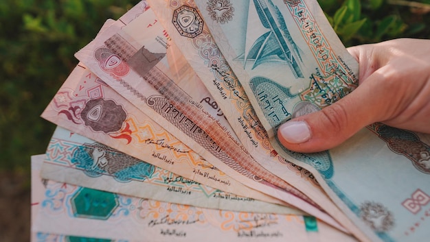 A hand holds a stack of banknotes with the word khabarovsk on it.