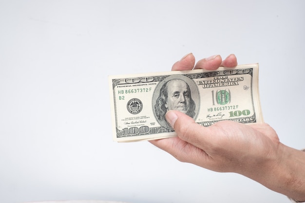 Hand holing American dollars banknotes on white background