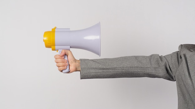 Photo hand is hold megaphone and wear grey suit on white background.