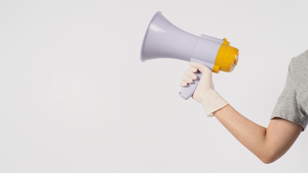 Hand is hold megaphone and wear medical glove on white background.