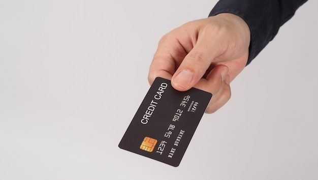 Hand is holding black credit card isolated on white background. Asian man hand.