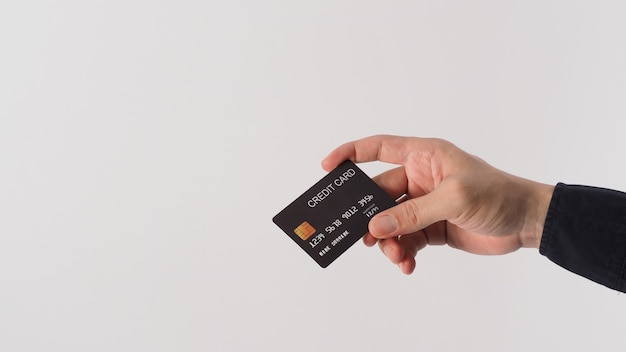 Hand is holding black credit card isolated on white background. Asian man hand.