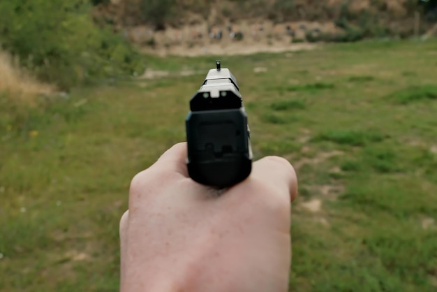 The hand is holding a firearm pistol training at the shooting range