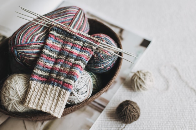 Photo hand knitted socks with needles and yarn ball concept for handmade and hygge slow life