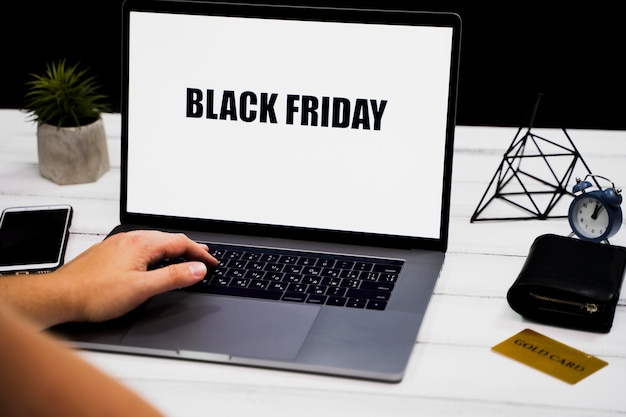 Hand on laptop keyword and black friday desktop