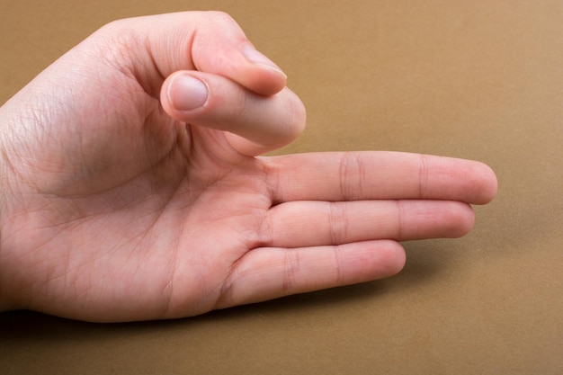 Hand making a gesture on wooden background