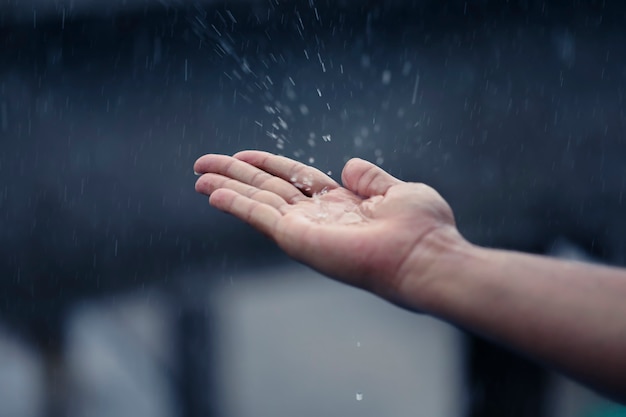 Hand of man catching raindrops.