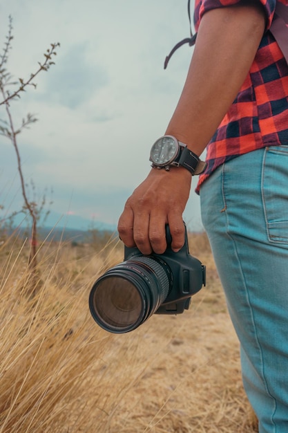 Hand of a man holding a camera in the mountain