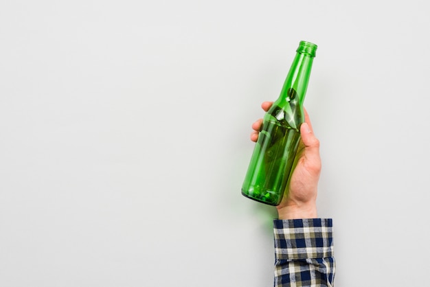 Photo hand of man holding glass bottle