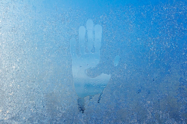 Photo hand marks on condensation window palm inprint