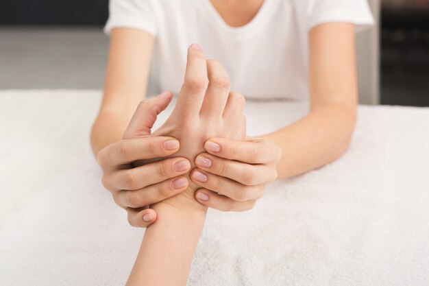 Hand massage. Physiotherapist pressing specific spots on female palm. Professional health and wellness acupressure manipulations, copy space, closeup