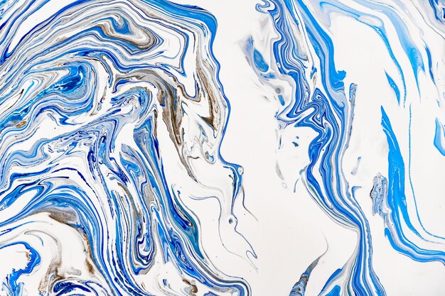 Hand painted background with mixed liquid blue, white, yellow paints. Abstract fluid acrylic painting.