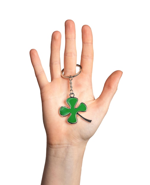 Hand palm holding shamrock green leaf shaped trinket isolated on white background