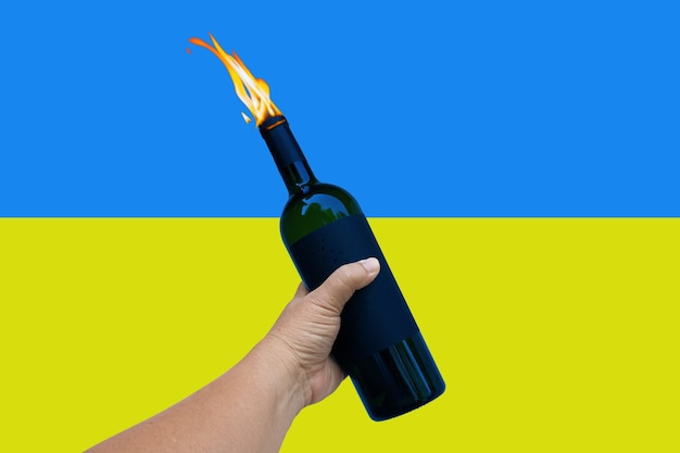 Hand of peace hold a fire bottle over Ukraine flag Pray For Ukraine Save Ukraine