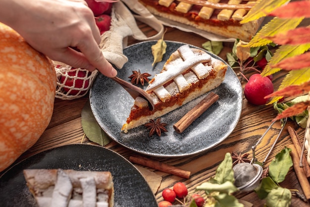 Hand of person is breaking off a piece of appetizing pie with a spoon Concept of a warm and cozy autumn atmosphere with the aroma of fresh tasty pastries