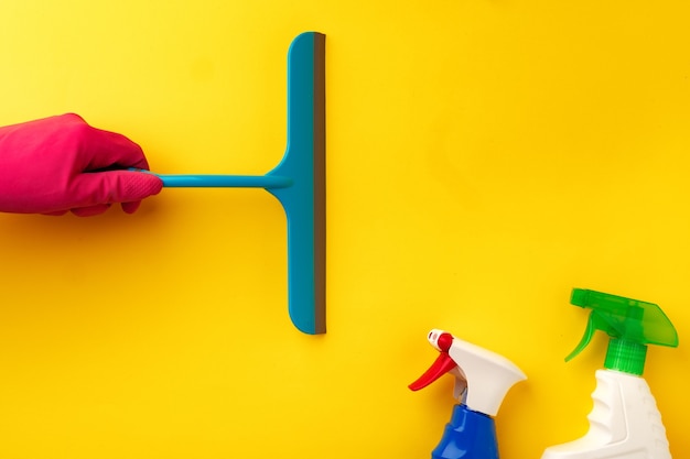 Hand in pink glove holding window cleaning brush