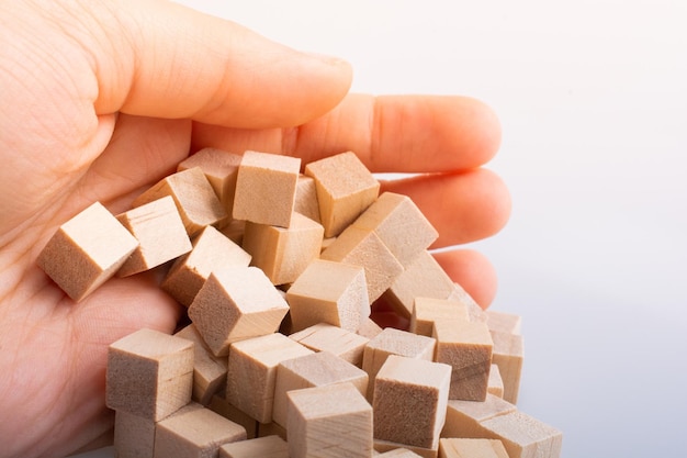 Hand playing with wooden toy cubes as educational games