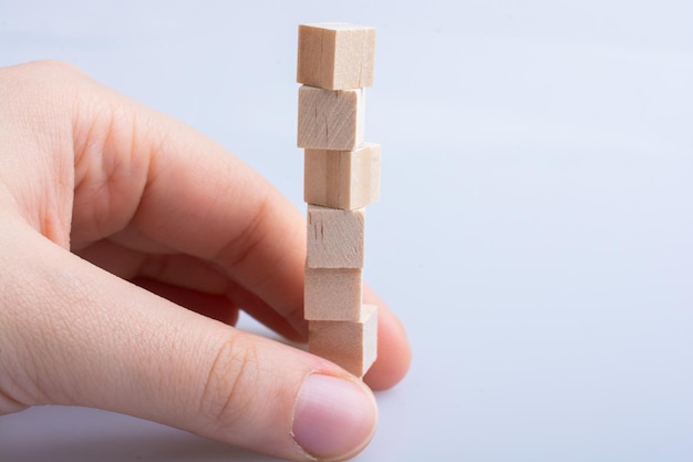 Hand playing with wooden toy cubes as educational games