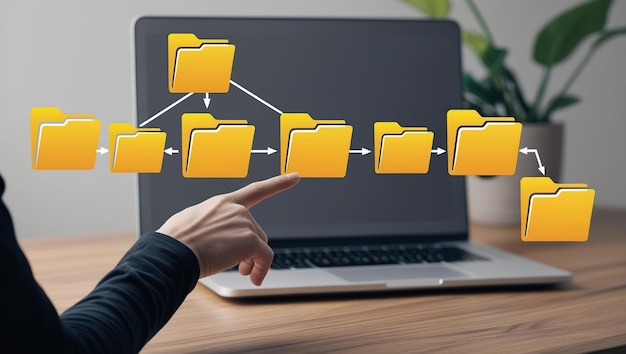 Photo hand pointing at a folder hierarchy displayed on a laptop screen symbolizing data organization and management