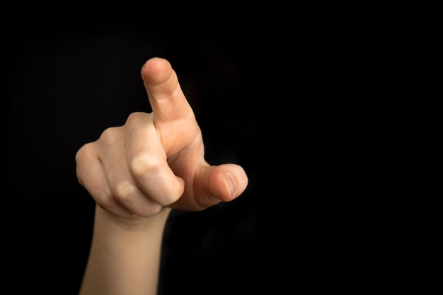 Hand pointing gesture on empty space on a black background