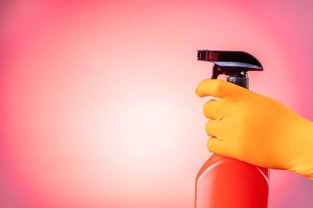 Hand in protective glove holding spray bottle Concept of cleaning service Copy space