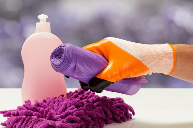 Hand in protective glove with garbage bags on blurred background