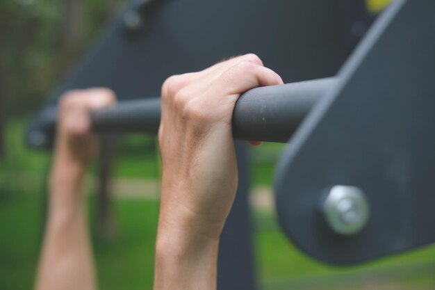 Photo hand on pullup bar close up work out on fresh air in the forest