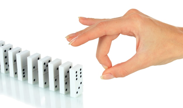 Hand pushing dominoes isolated on white