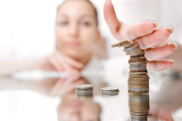 Hand pushing a pile of coins, column of coins falls , business crisis concept. shallow focus. High quality photo