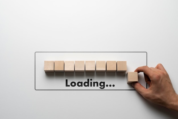 A hand put a wooden cube in a row loading progress bar