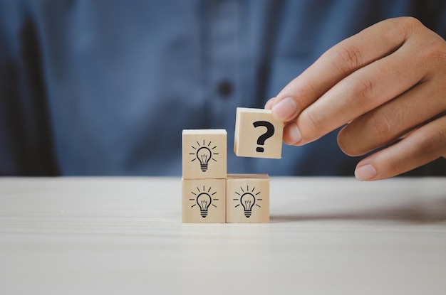 Hand put wooden cubes with question mark symbol on table and copy spaceBusiness concepts