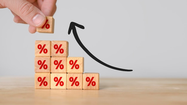 Hand putting wood cube block increasing on top with icon percentage symbol upward direction