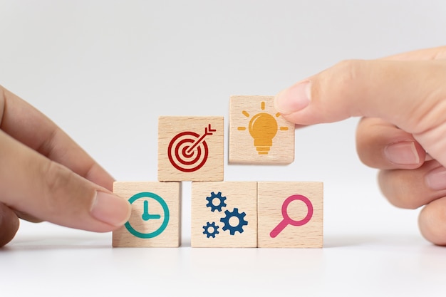 Hand putting wooden cube block stacking with icon on white background