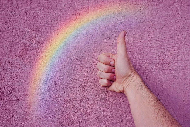 Hand and rainbow on the pink wall lgbt symbol