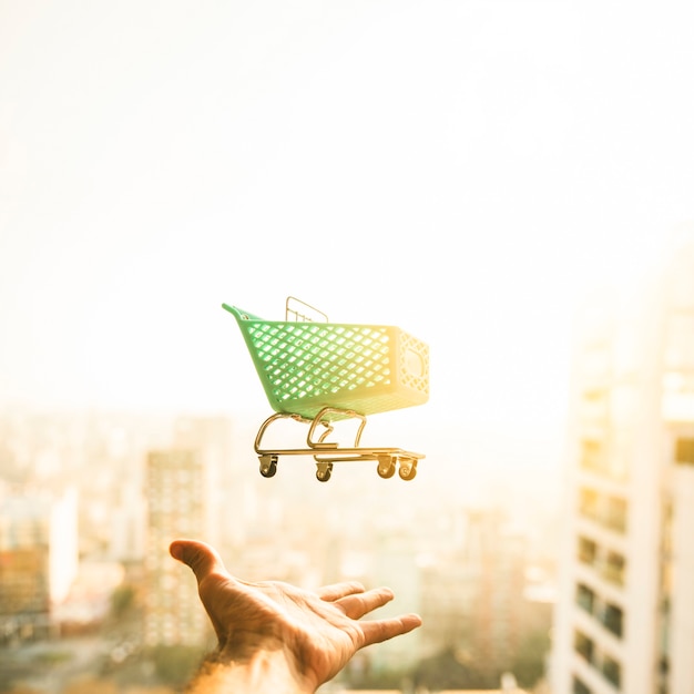 Hand reaching for grocery cart on blurred background