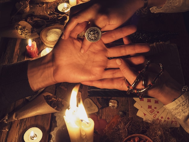 Hand reading in the dark. Candles and attributes of the occult